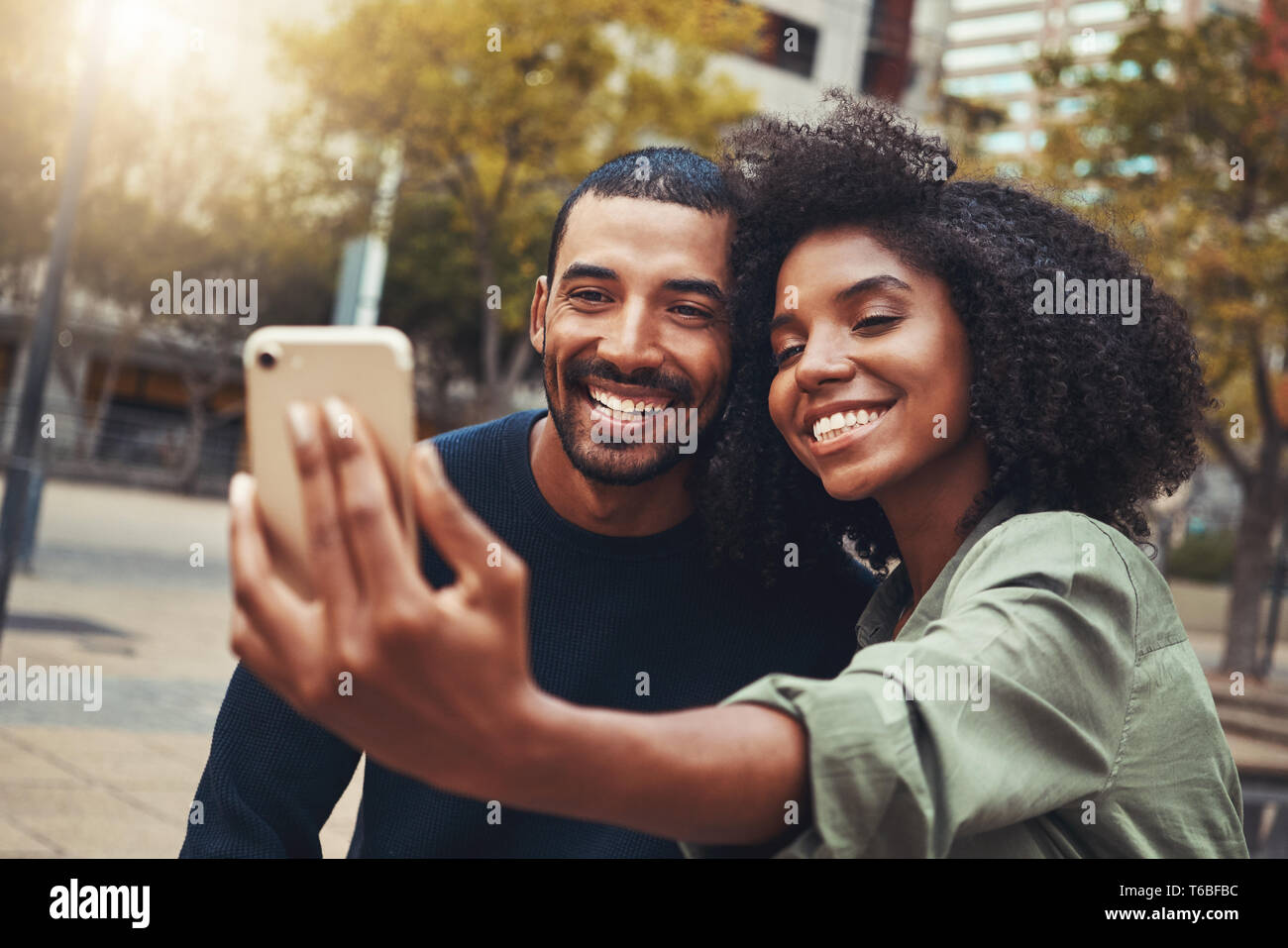 Sorridente coppia giovane tenendo selfie nel parco della città Foto Stock