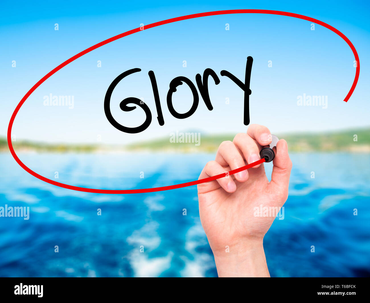 Man mano che scrive la gloria con pennarello nero su schermo visivo Foto Stock