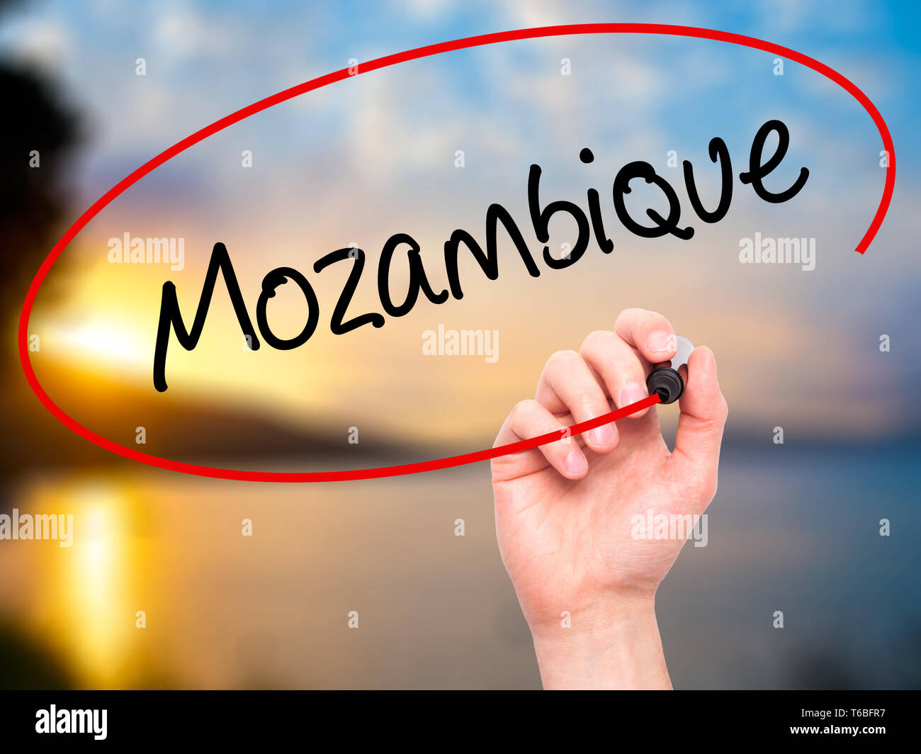 Man mano che scrive il Mozambico con pennarello nero su schermo visivo Foto Stock