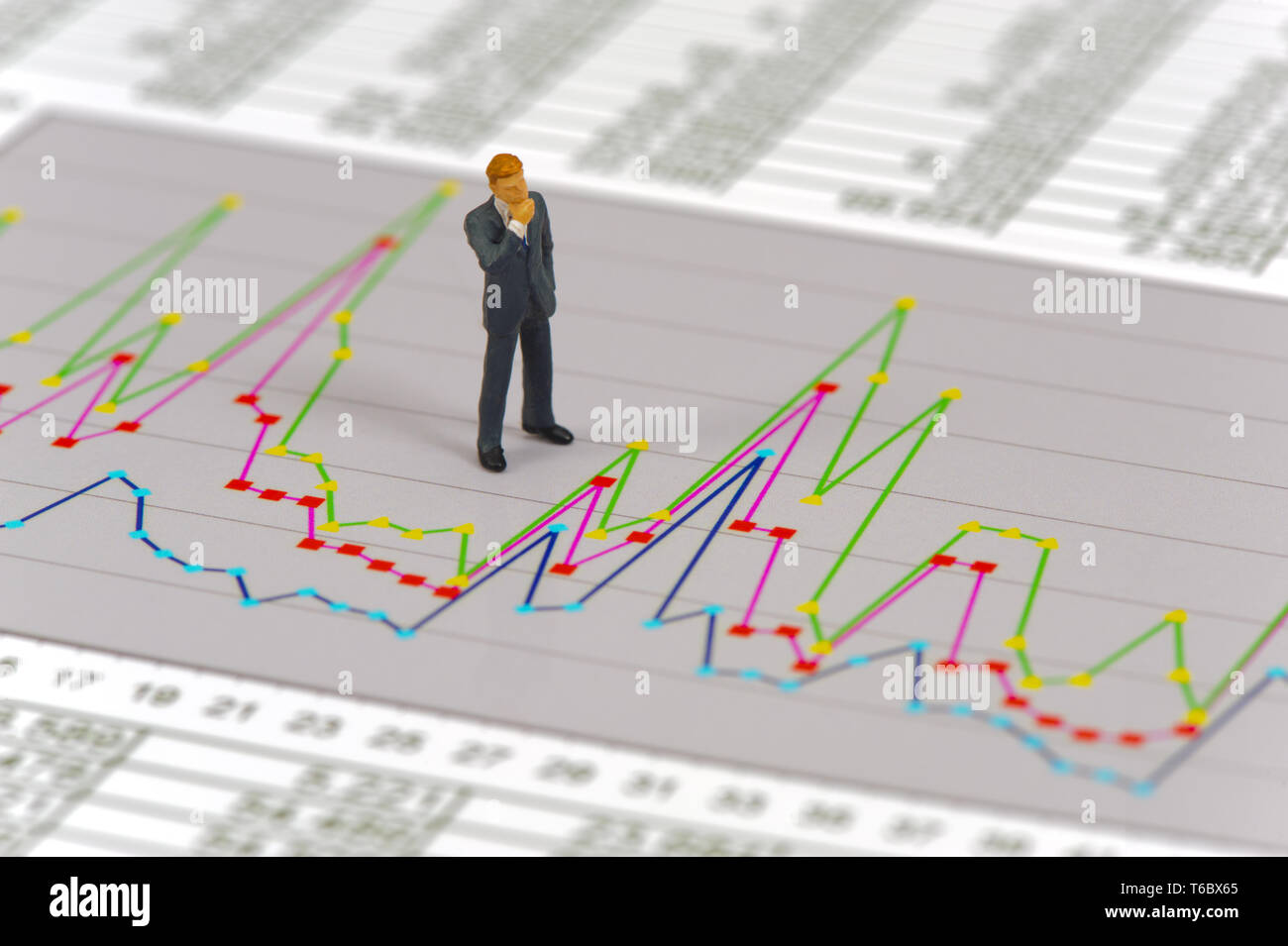 Figura di modello del banchiere è pensando a grafici e strategia del mercato azionario Foto Stock
