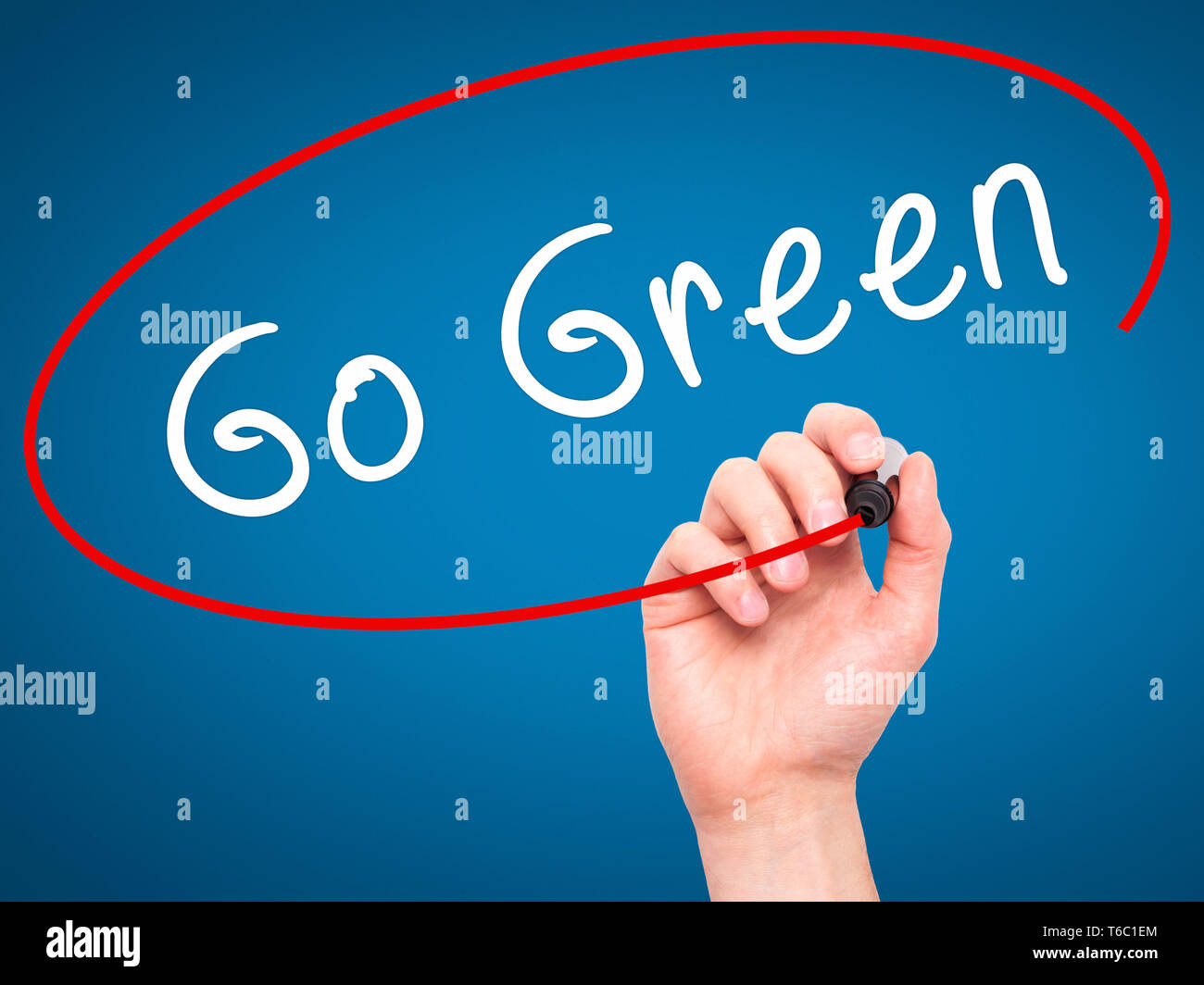 Man mano che scrive Go Green con pennarello nero su schermo visivo Foto Stock