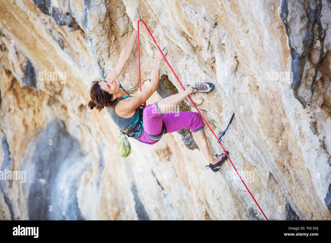 Giovani caucasici donna climbing impegnativo percorso sulla rupe a strapiombo Foto Stock