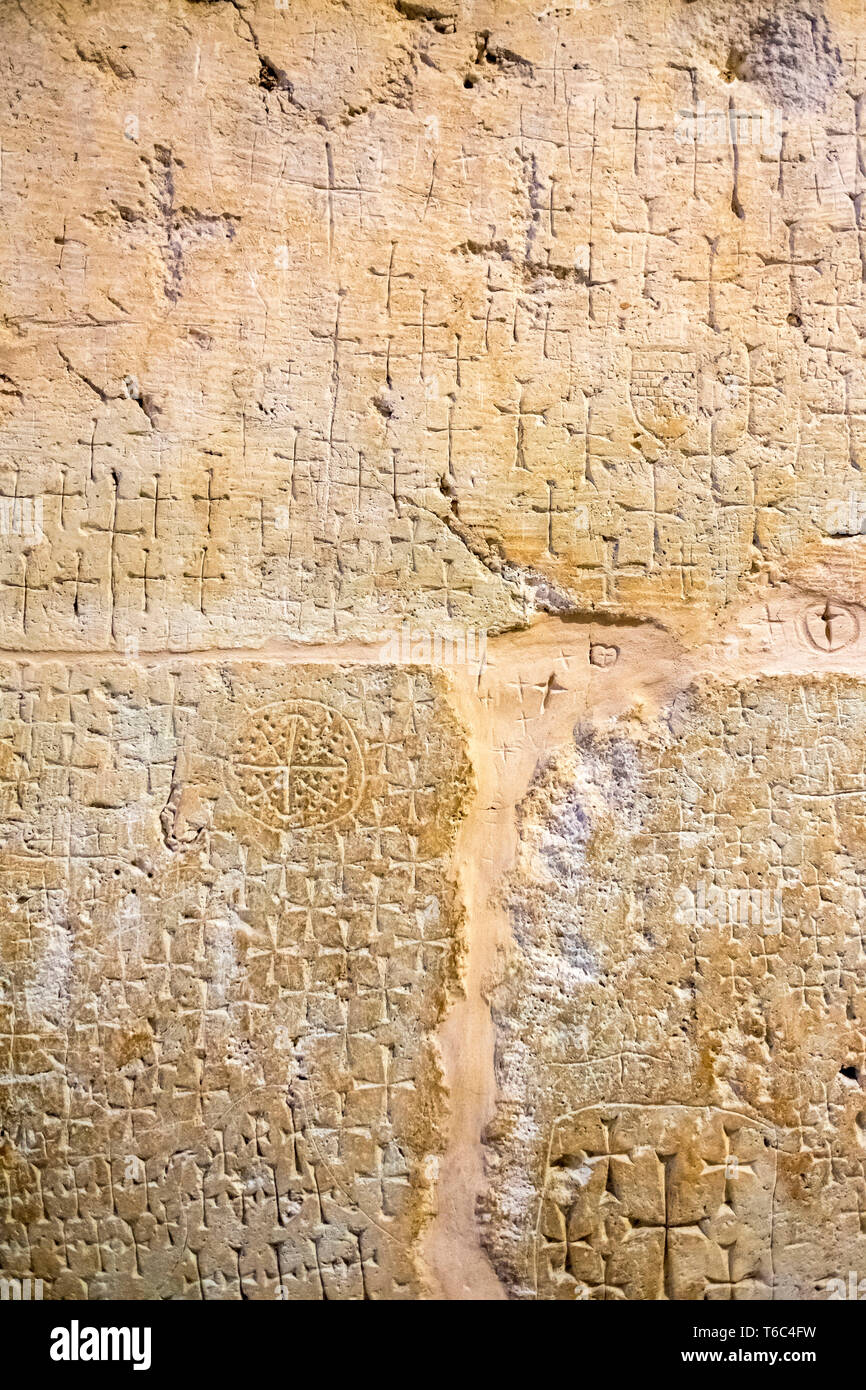 Antica croci scolpite dai pellegrini contrassegnando la posizione di Gesù' sepoltura nelle grotte sotto la chiesa del Santo Sepolcro. Foto Stock