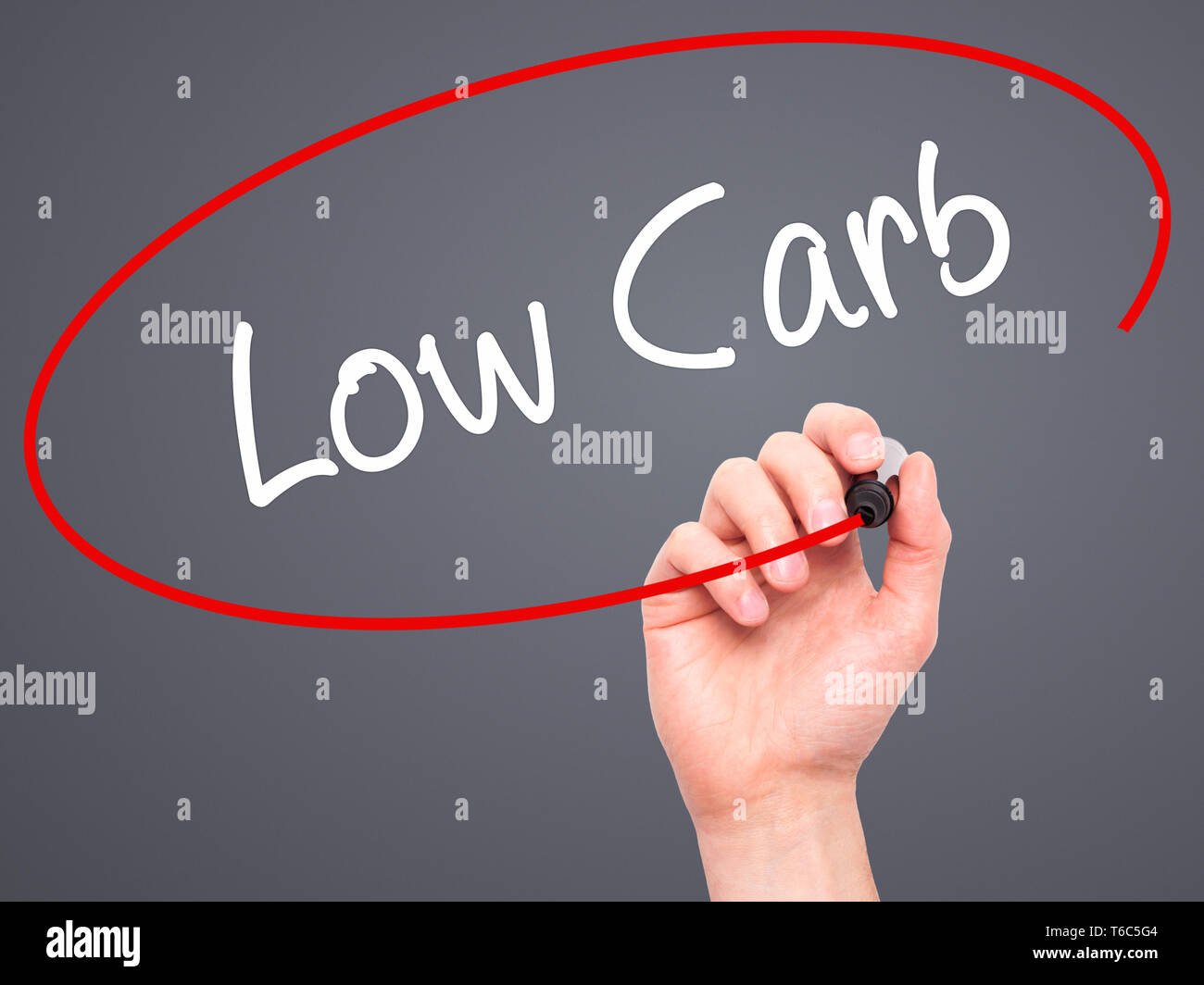 Man mano che scrive il carburatore basso con pennarello nero su schermo visivo Foto Stock