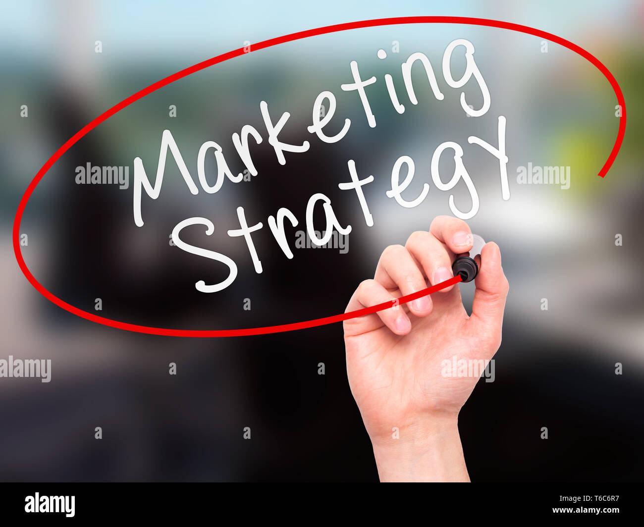 Man mano che scrive la strategia di marketing con marcatore sul trasparente scheda di pulizia Foto Stock