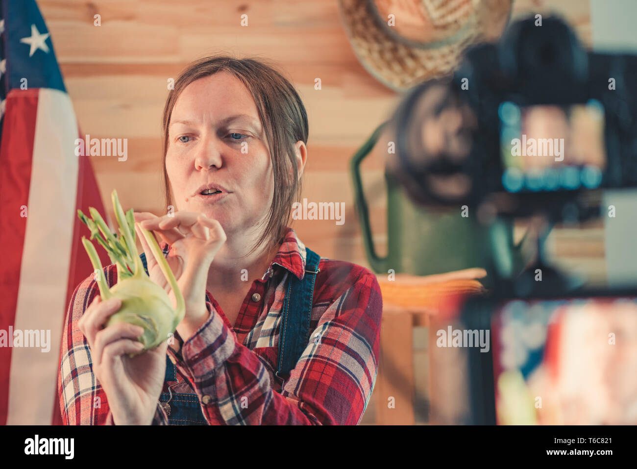 L'agricoltore femmina rendendo i social media vlog video sul lavoro agricolo stagionale e attività agricola, Donna vestita come lavoratore agricolo interessato nella parte anteriore della fotocamera t Foto Stock