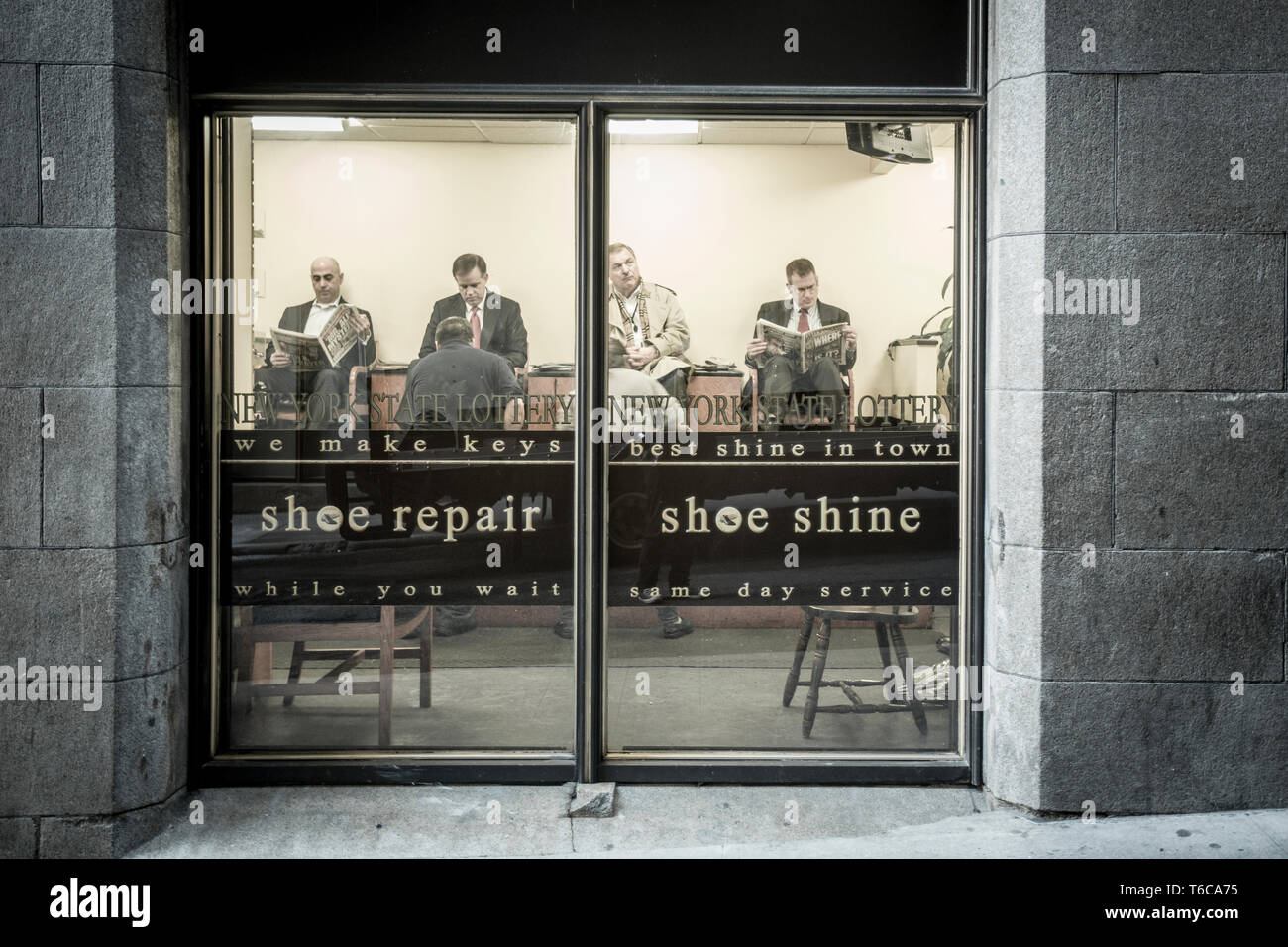 Gli uomini in attesa di avere le loro scarpe lucidate e lucidate a Stanley Shoe Repair. Secondo le persone nel sapere, la Stanley offre il miglior lustrascarpe di tutti i calzolai nel quartiere finanziario. Foto Stock