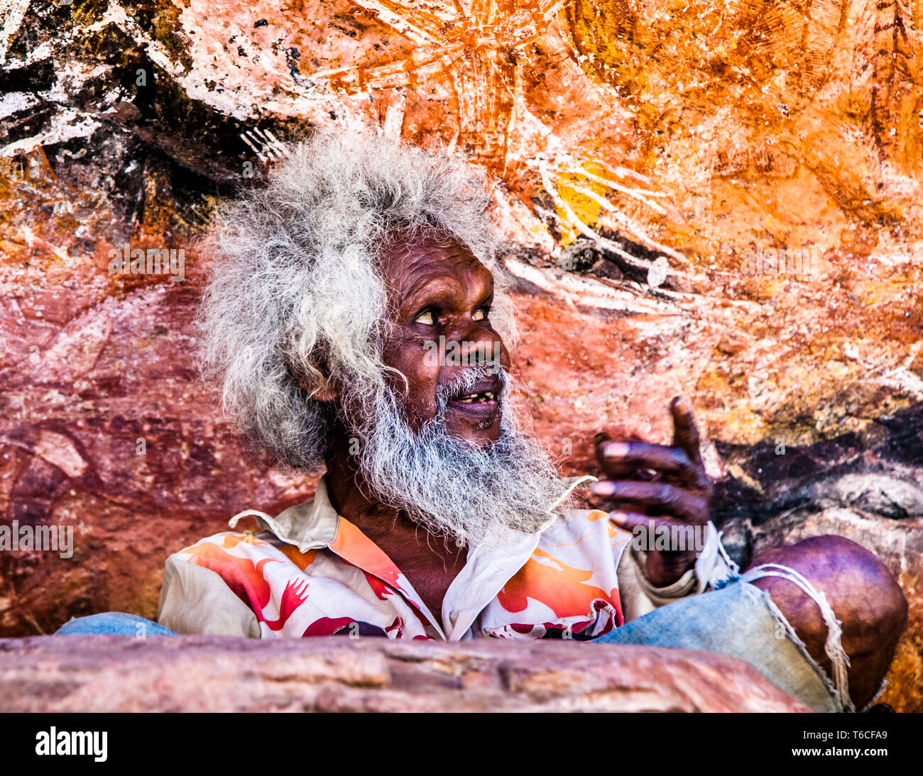 Le storie prendono vita. Guida nativa che spiega l'arte rupestre aborigena a Long Tom Dreaming, Gunbalanya, Australia Foto Stock