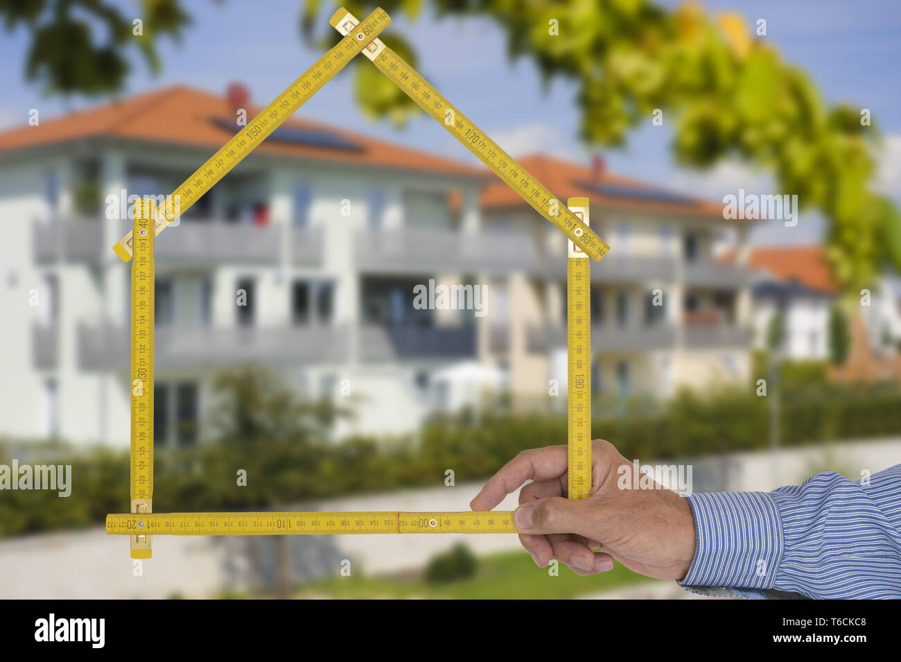 Guscio di casa in costruzione con righello in mano di agente immobiliare Foto Stock