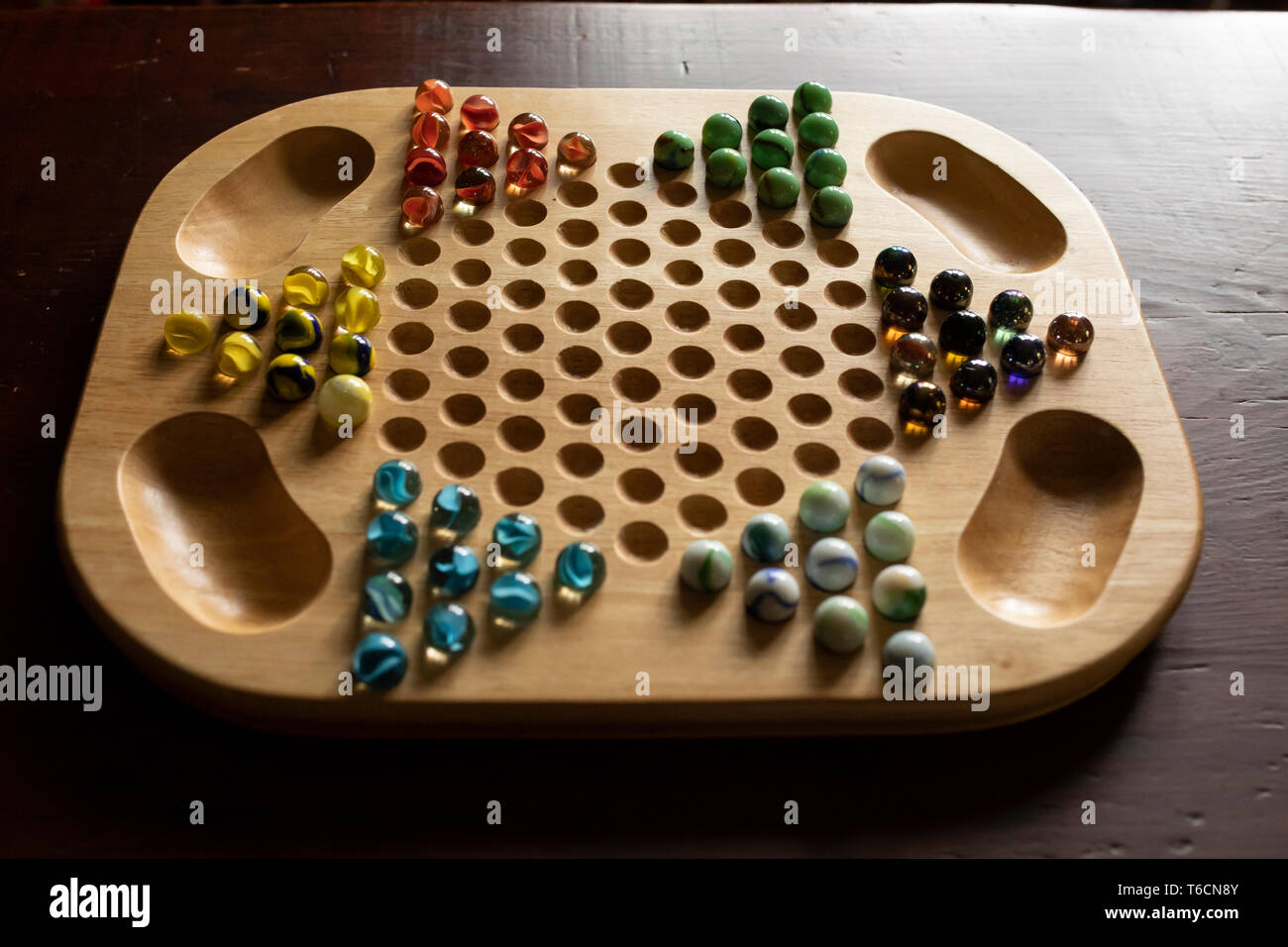Un Cinese in legno gioco Dama a bordo con marmi di diverso colore, seduto su un legno di ciliegio tavolo. Foto Stock
