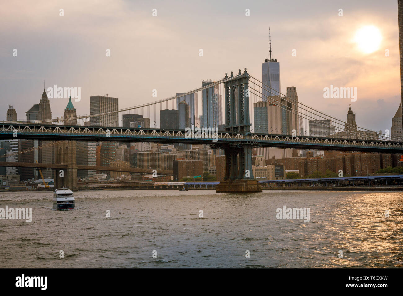 Sonnenuntergang und Boote auf dem East River unter der Brücke am 04.07.2018 zum Unabhängigkeitstag Empire / Tramonto nave su East River sotto il ponte Foto Stock