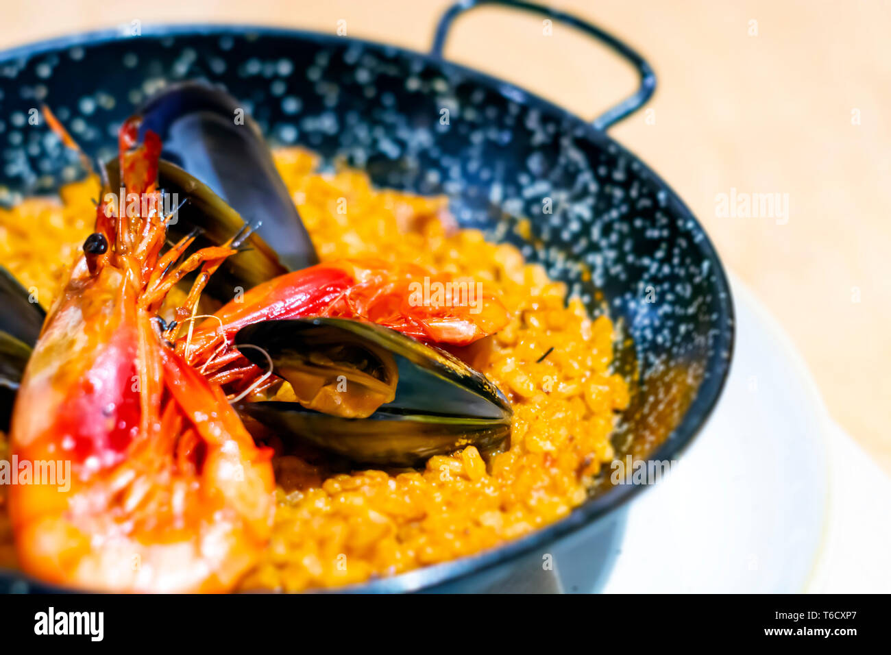 La paella di mariscos in una padella nera, un piatto tipico della cucina tradizionale spagnola, a base di pesce e di riso. Cucina tradizionale Foto Stock