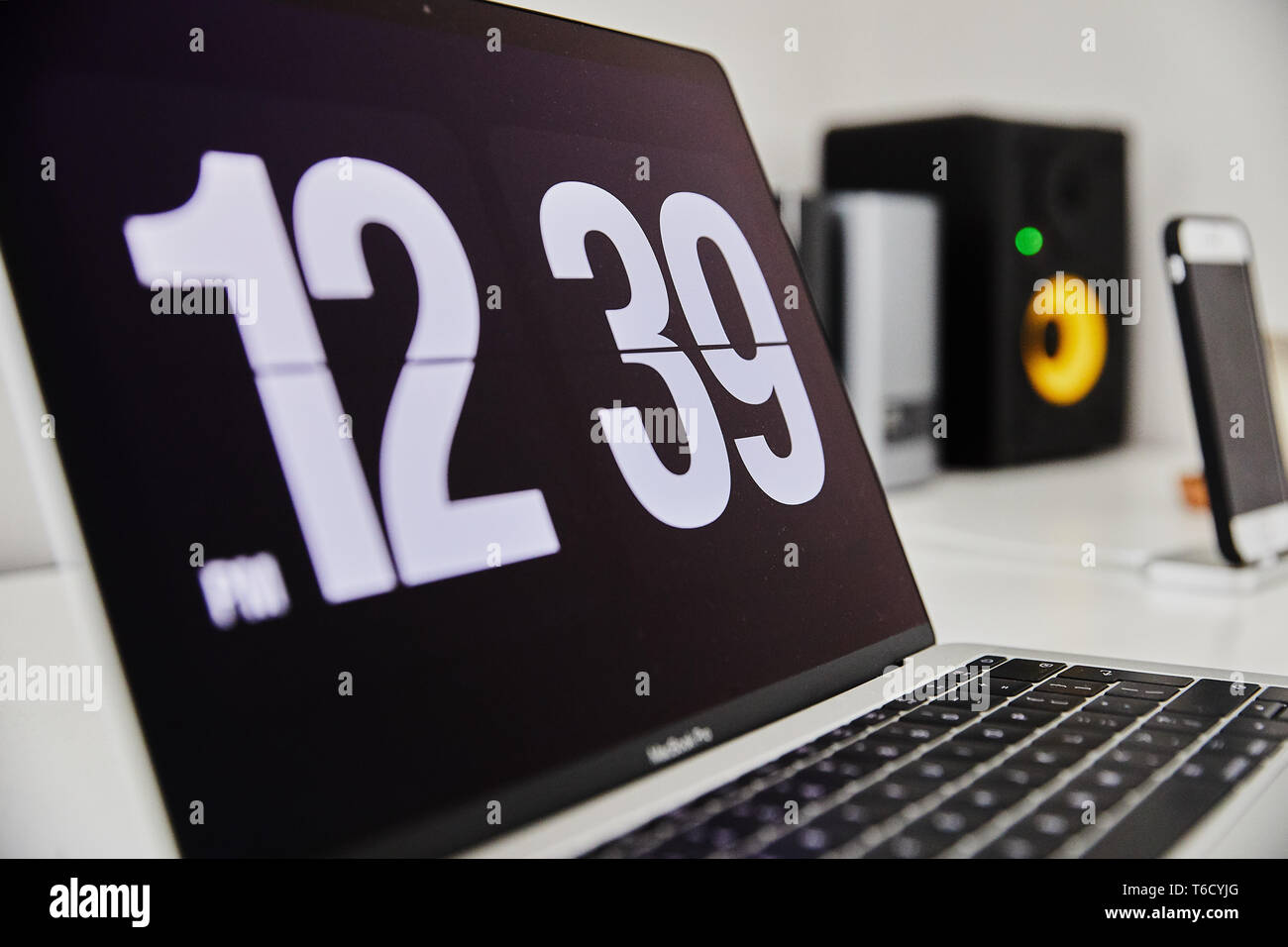 Apple MacBook Pro notebook con l'orologio screensaver sul grande bianco  Ikea desk office con il nero giallo altoparlanti, iPhone in background Foto  stock - Alamy