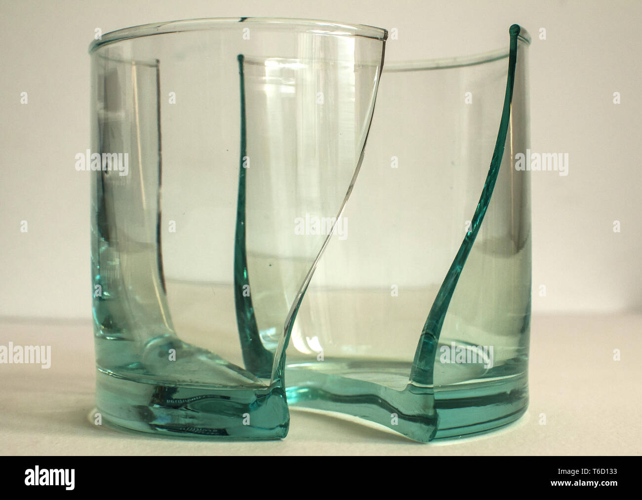 Rotto il vetro trasparente cup in due parti simmetriche closeup Foto Stock