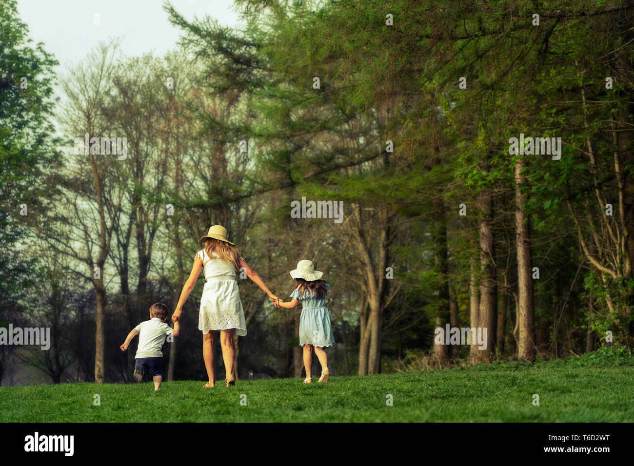 E per il divertimento di tutta la famiglia nel parco esterno in natura con mamma figlio e figlia. indossare abiti estivi Foto Stock