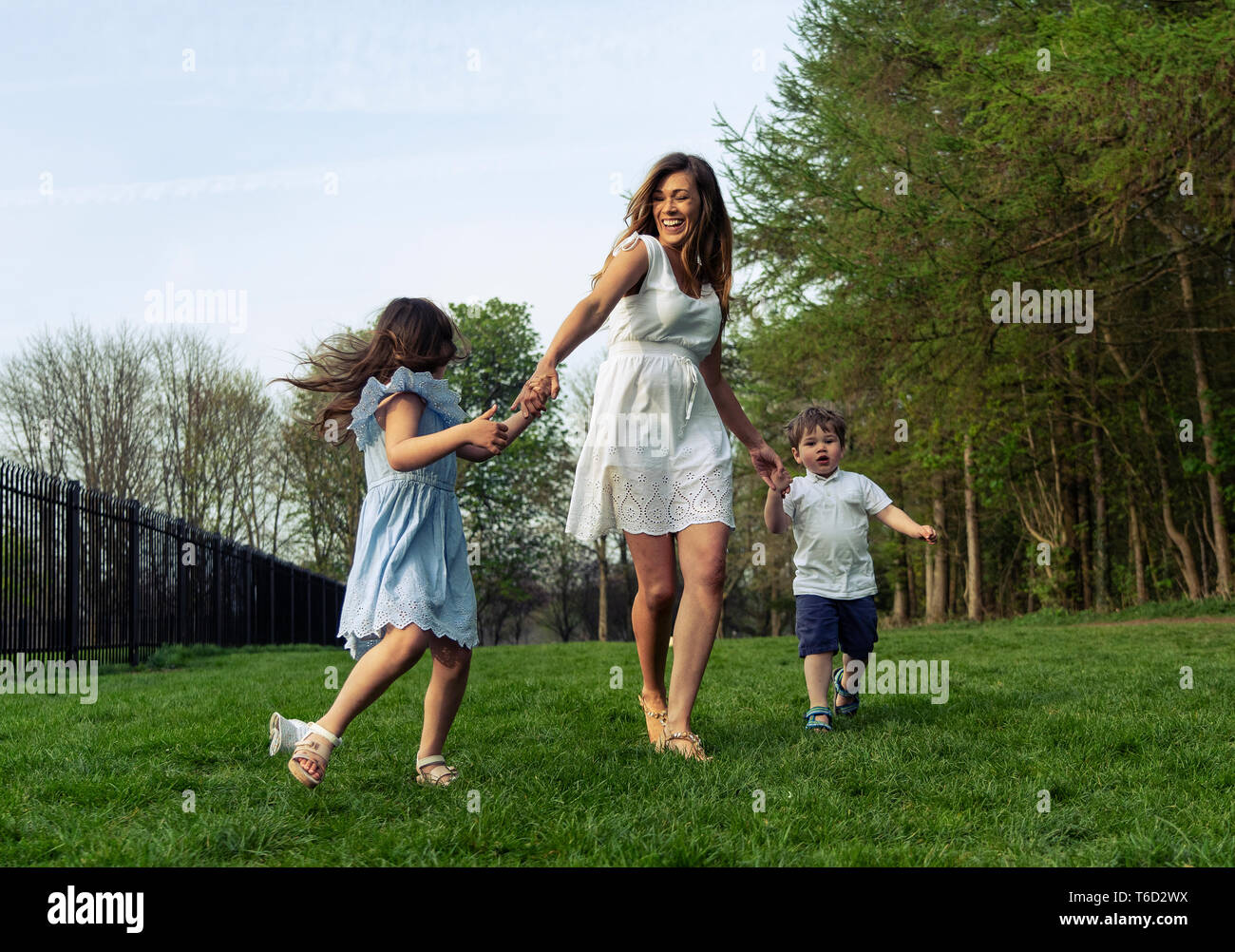 E per il divertimento di tutta la famiglia nel parco esterno in natura con mamma figlio e figlia. indossare abiti estivi Foto Stock