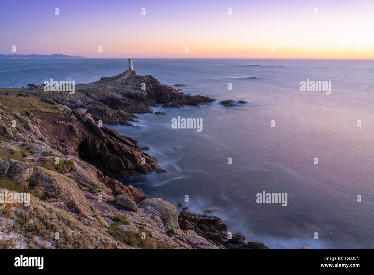 Spagna Galizia, Roncuda, panoramica della baia e del faro al tramonto Foto Stock