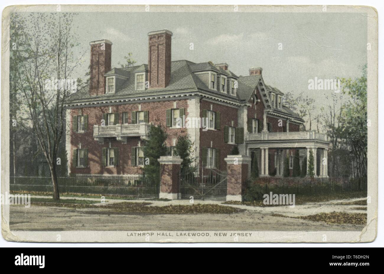 Cartolina con un'immagine a colori che illustra una vista laterale del rosso-mattone, multistory Classical-Revival, facciata di Lathrop Hall; con una strada, marciapiede e caduta foglie visibile in primo piano; situato in Lakewood, New Jersey, 1914. Dalla Biblioteca Pubblica di New York. () Foto Stock