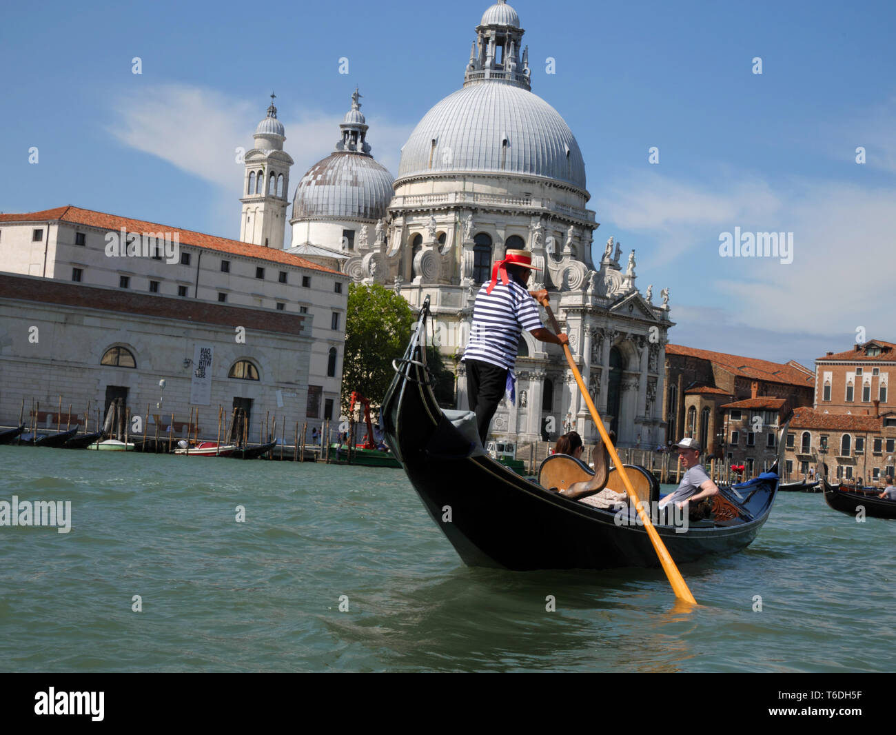 Gondoliere, Grand Canal, Venezia. Basilica di Santa Maria della Salute in background. Foto Stock