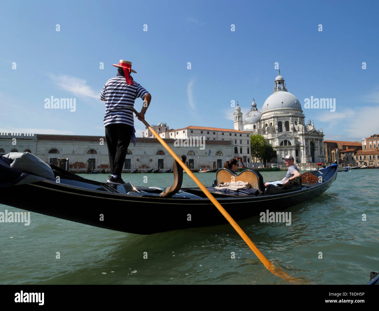 Gondoliere, Grand Canal, Venezia. Basilica di Santa Maria della Salute in background. Foto Stock