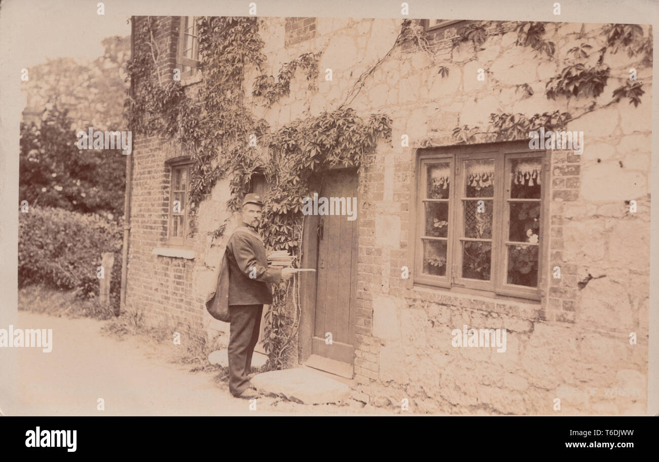 Vintage Isle of Wight Edwardian Cartolina fotografica che mostra un postino britannico la consegna di posta. Postato da Brading nel 1906. Foto Stock