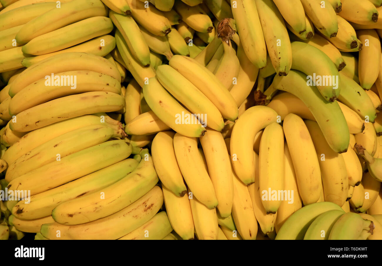 Pila di fresche e mature di vendita delle banane nel mercato Foto Stock