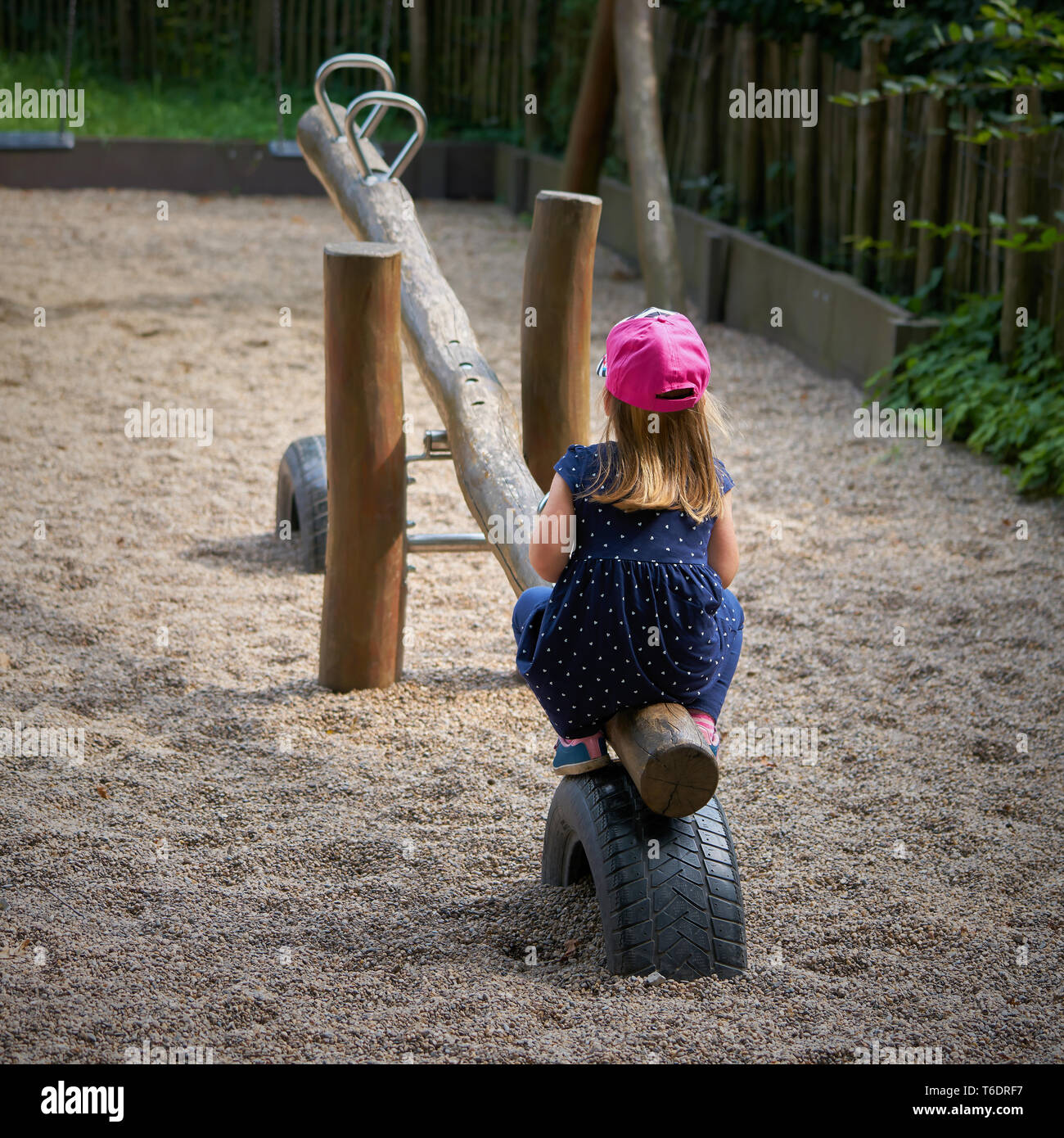 Lonely bambina da sola su un parco giochi Foto Stock