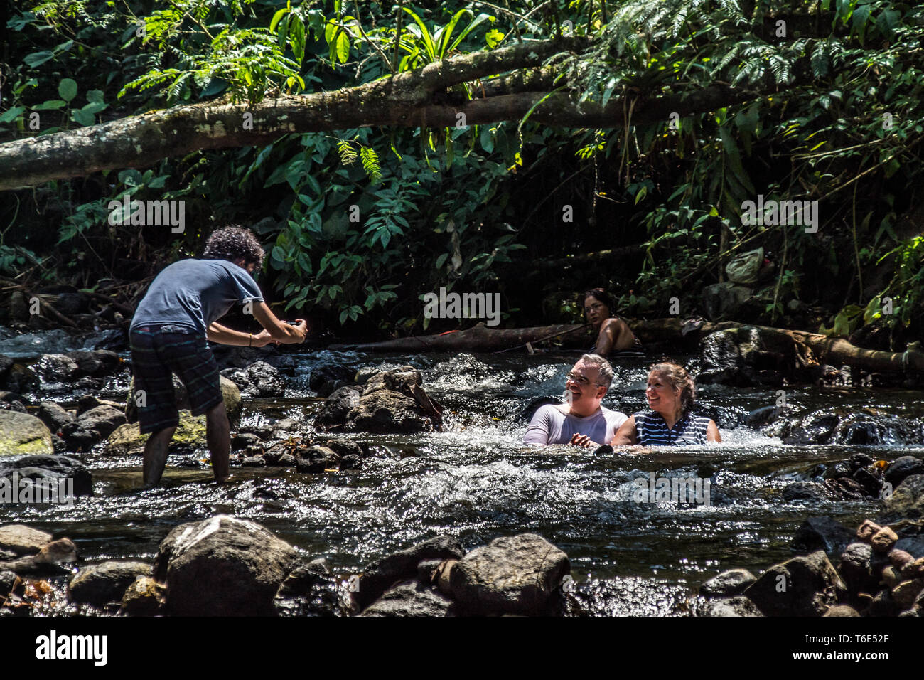 Una bella foto di un ragazzo di scattare le foto di una coppia di sposi godendo il bellissimo panorama naturale ecotermales (hot springs) a Tabacon, La Fortuna, Costa Rica Foto Stock