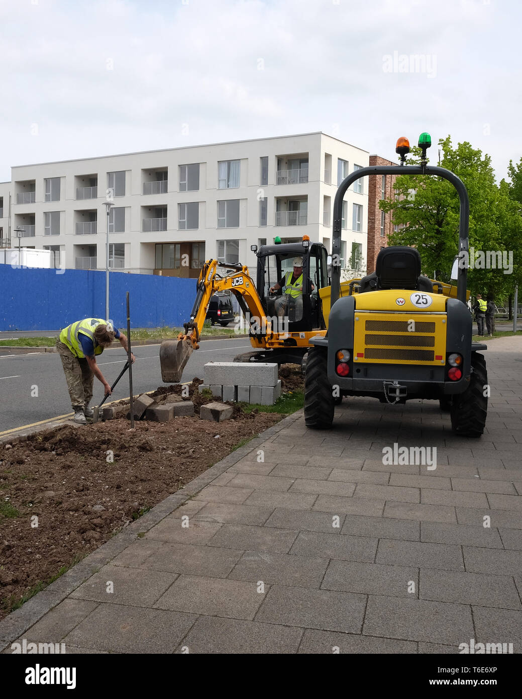 Aprile 2018 - lavoratori edili posa di cordoli di marciapiede accanto a una strada in Portishead, North Somerset, Regno Unito Foto Stock