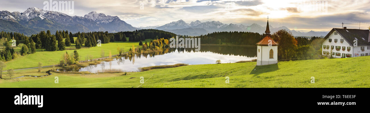 Panorama rurale scena con montagne alpine fattoria, casa e la cappella in Baviera Foto Stock