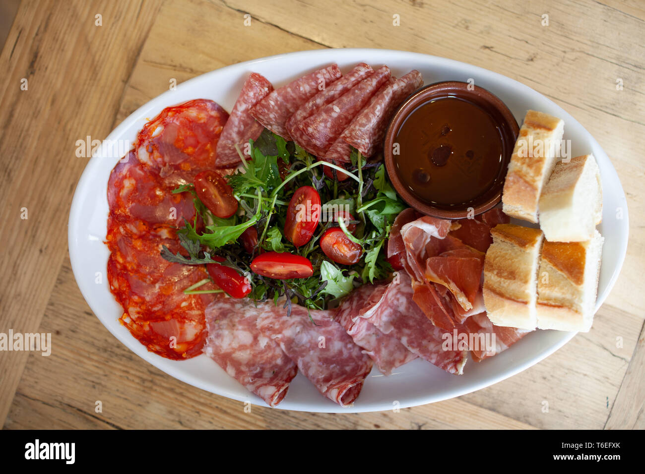 Un piatto misto di salumi e insalata servita con fette di pane francese Foto Stock