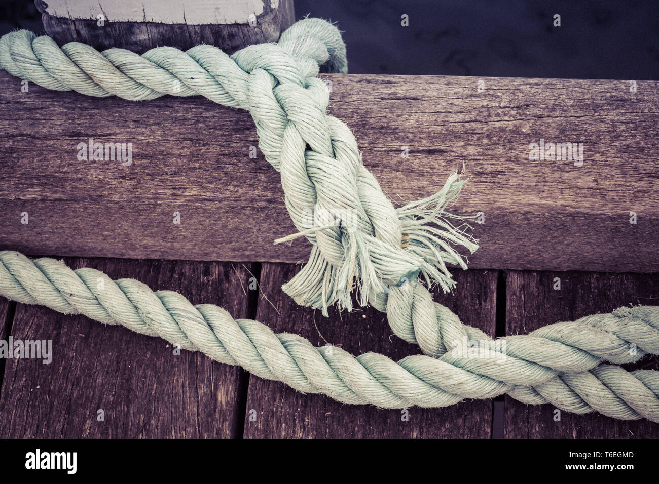 Usurati di spessore la cima di ormeggio sul molo in legno closeup Foto Stock