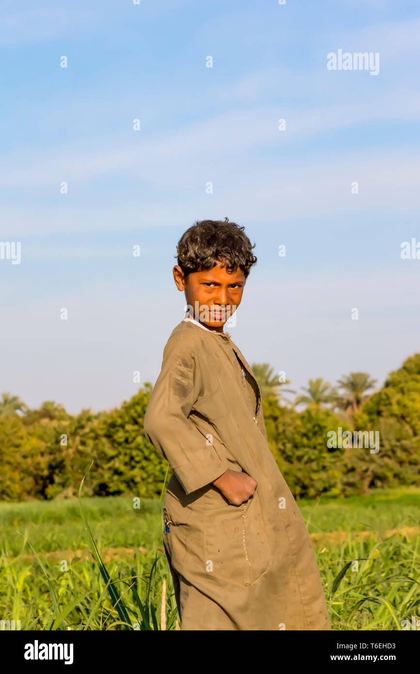 Fattoria egiziano ragazzo indossa galabaya a piedi attraverso il campo Foto Stock