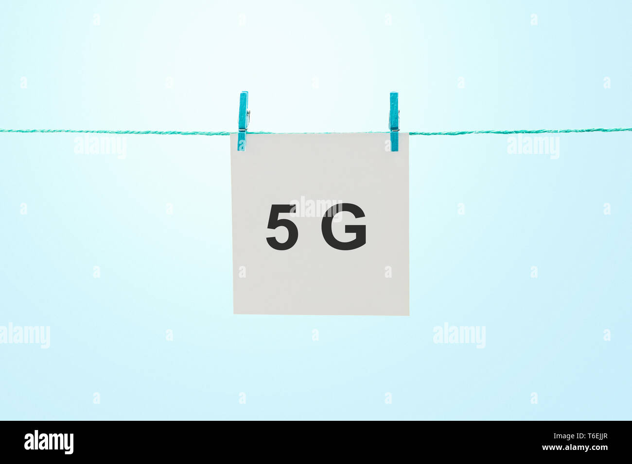 Parola 5G su bianco nota carta appeso alla fune contro sunny blue sky Foto Stock