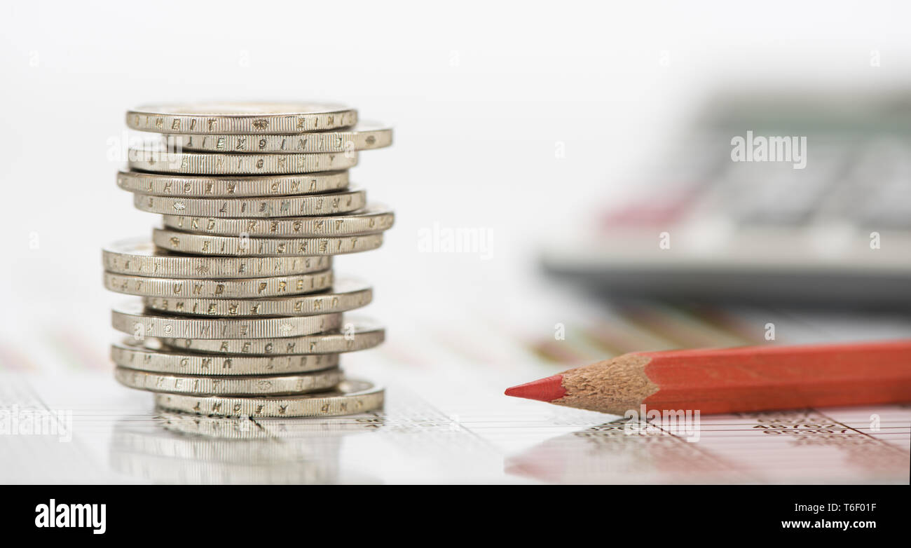 Impilate le monete in euro e la calcolatrice posa su attività finanziarie grafico del mercato azionario Foto Stock