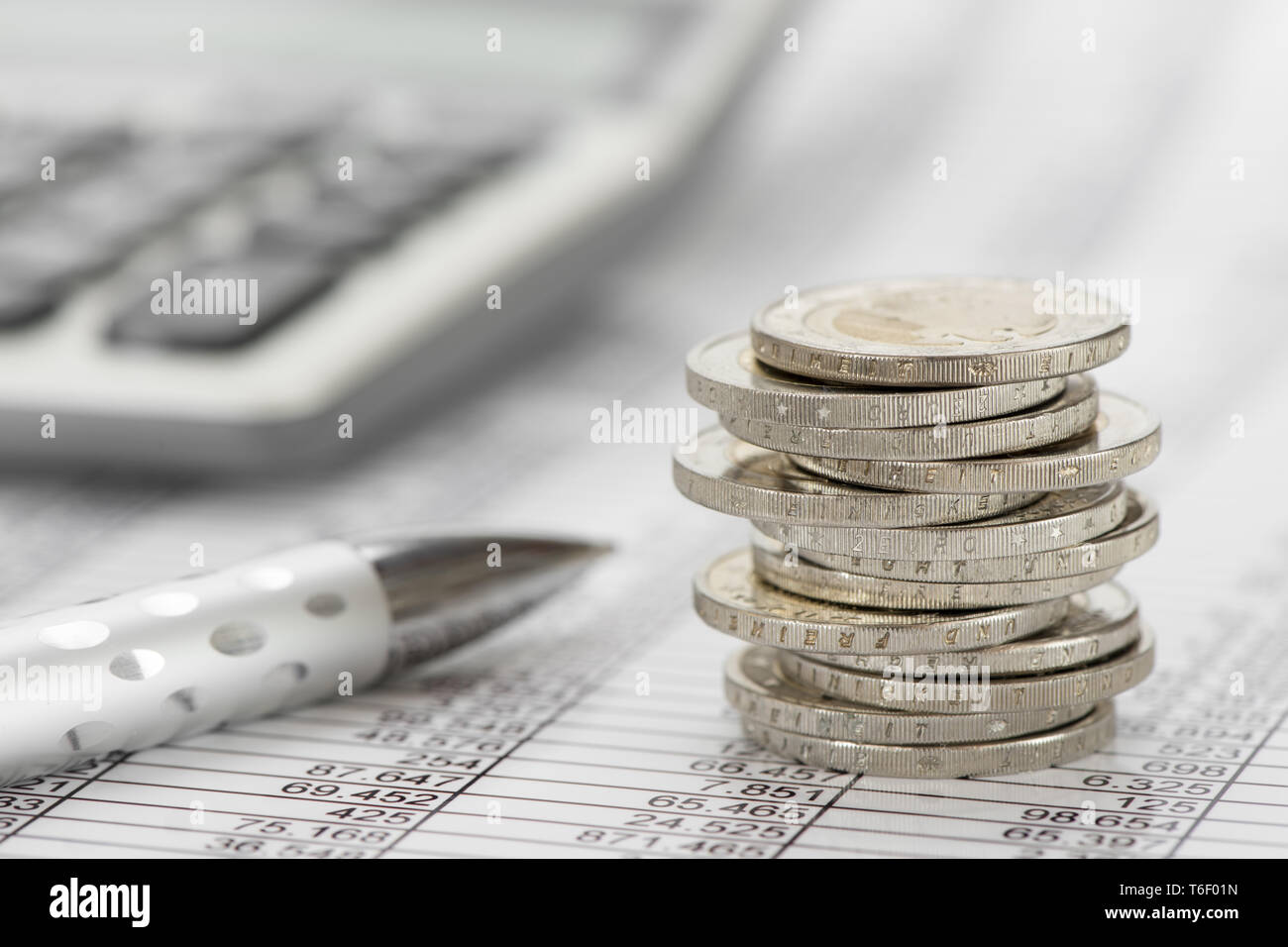 Impilate le monete in euro e la calcolatrice posa su attività finanziarie grafico del mercato azionario Foto Stock