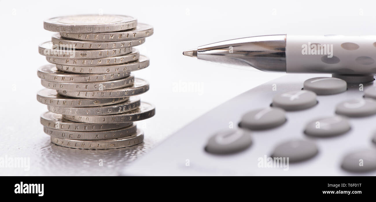 Impilate le monete in euro e la calcolatrice posa su attività finanziarie grafico del mercato azionario Foto Stock