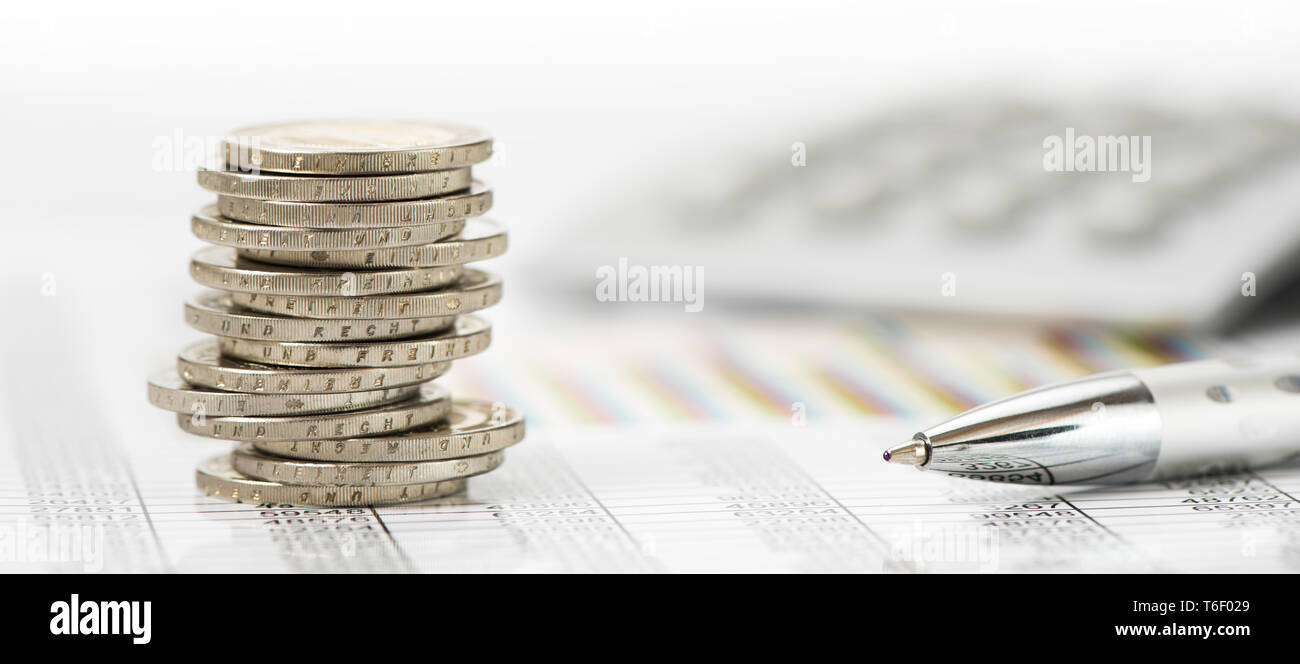 Impilate le monete in euro e la calcolatrice posa su attività finanziarie grafico del mercato azionario Foto Stock