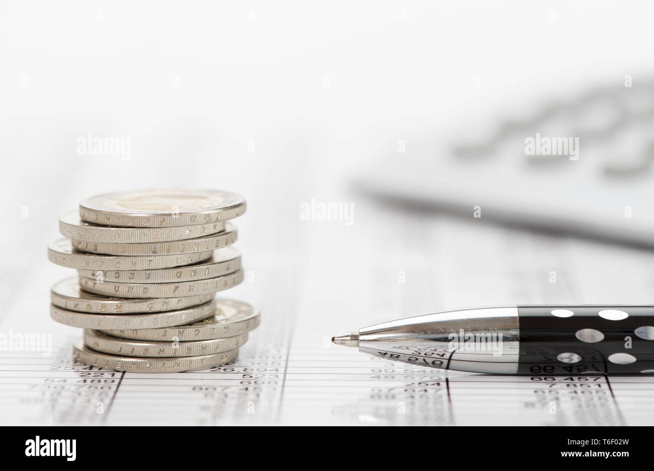 Impilate le monete in euro e la calcolatrice posa su attività finanziarie grafico del mercato azionario Foto Stock