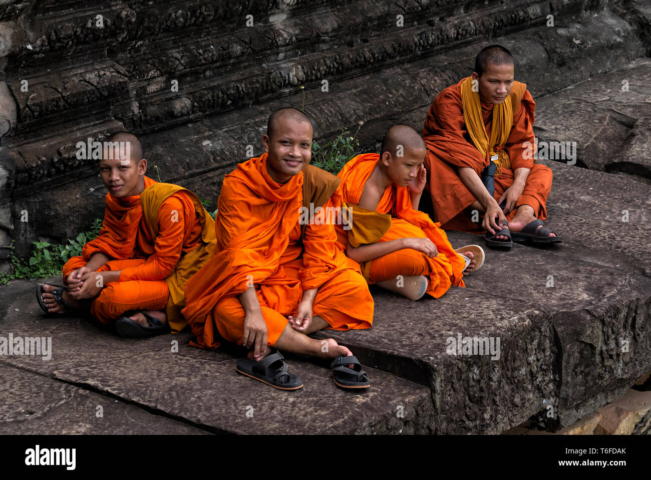 Un gruppo di monaci buddisti in un momento di relax a Angkor Wat in Siem Reap, Cambogia Foto Stock