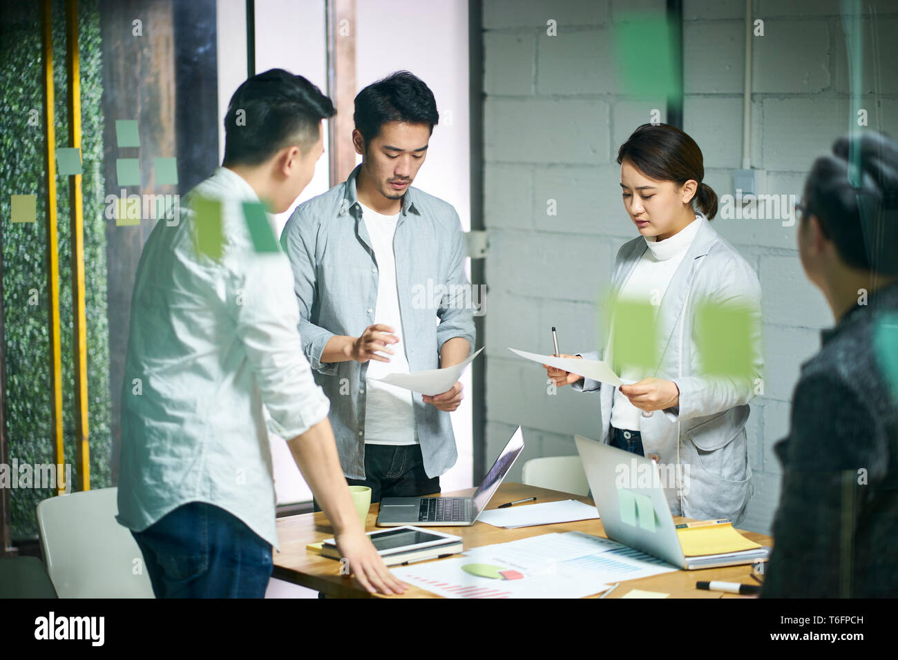 Giovani imprenditori asiatici di piccola impresa a discutere di business plan in office sala riunioni. Foto Stock