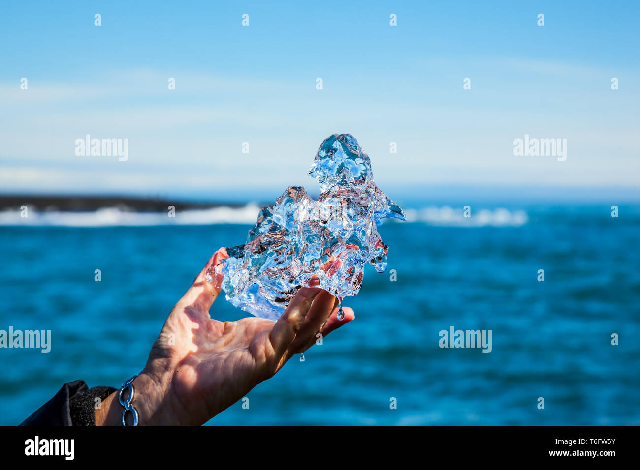 Trasparente pezzo di ghiaccio in mano Foto Stock