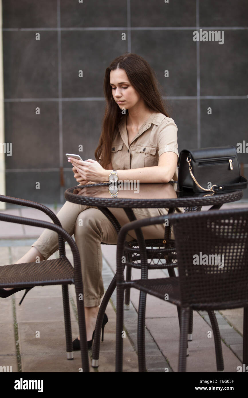 Bella ragazza utilizzando smart phone all'aperto Foto Stock