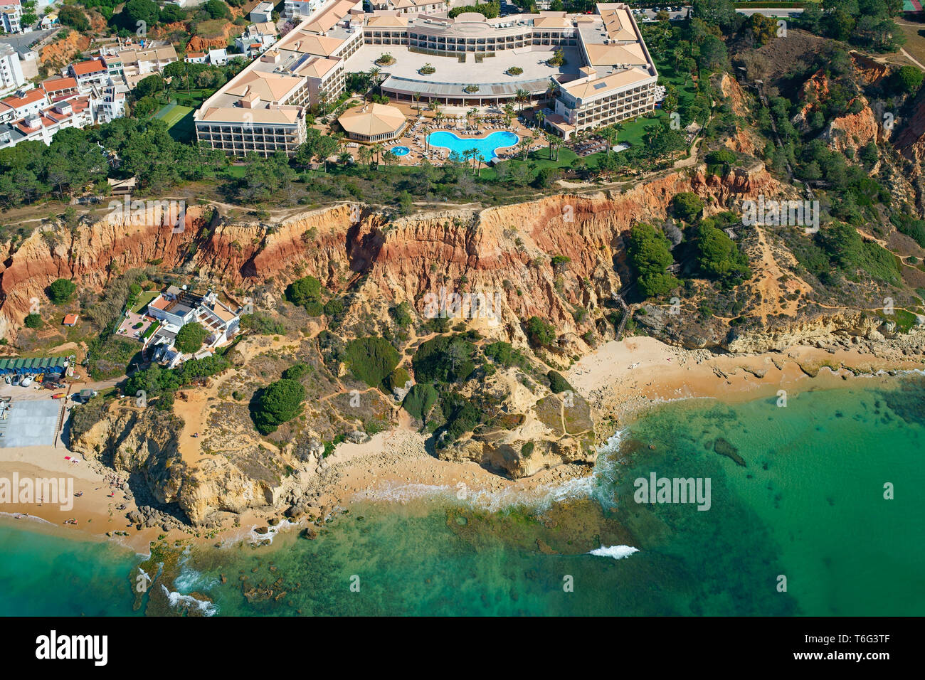 VISTA AEREA. Resort di lusso affacciato sulle colorate scogliere di Praia da Falésia sulle rive dell'Atlantico. Olhos de Agua, Albufeira, Algarve, Portogallo. Foto Stock