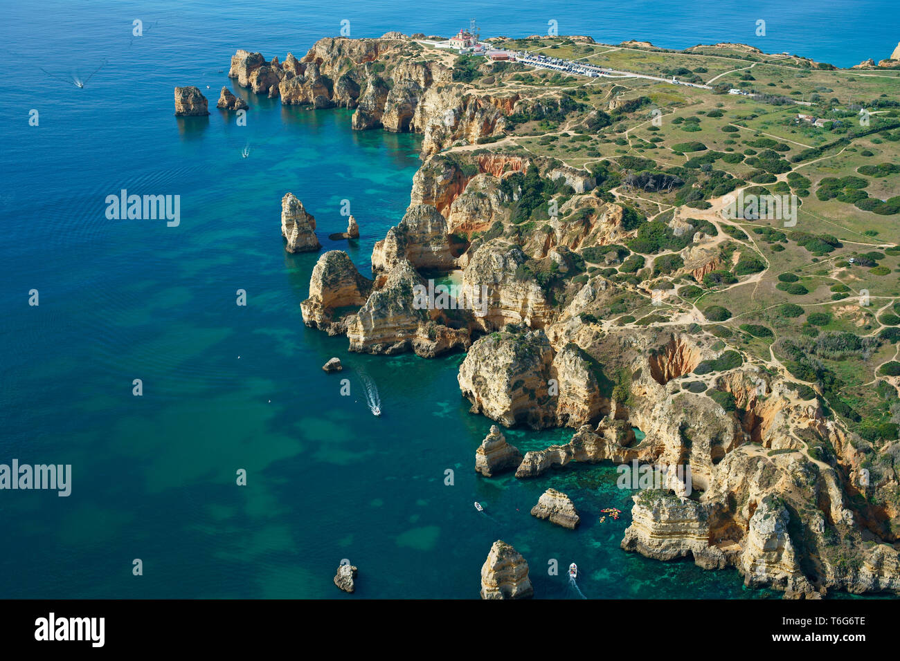 VISTA AEREA. Paesaggio costiero profondamente eroso con molte buche, grotte marine e insenature. Ponta da Piedade, Lagos, Algarve, Portogallo. Foto Stock