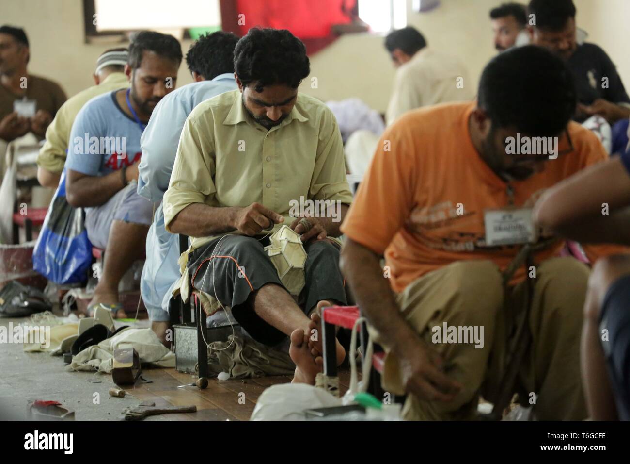 Sialkot. Xii Apr, 2019. Foto realizzata il 12 aprile 2019 illustra i lavoratori palloni di cucitura in corrispondenza di una fabbrica di calcio nella parte orientale del Pakistan Sialkot. Sialkot, una città nella provincia pakistana del Punjab, è un centro di cucito a mano il calcio rendendo nel mondo e nel suo momento di gloria, la città era una volta di catering per più di 75 percento del totale della domanda mondiale di calcio. Credito: Ahmad Kamal/Xinhua/Alamy Live News Foto Stock