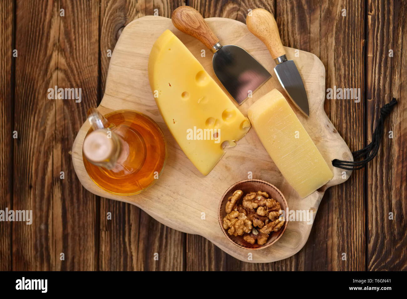 Due tipi di Formaggi - Parmigiano e gouda con noci e miele sulla tavola di  legno con coltelli per formaggi Foto stock - Alamy