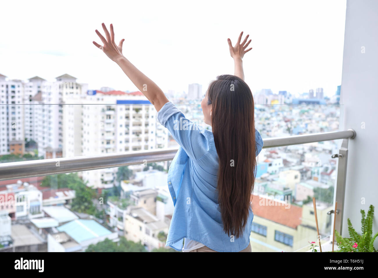 Vista posteriore del attiva donna sportiva stretching sul balcone Foto Stock