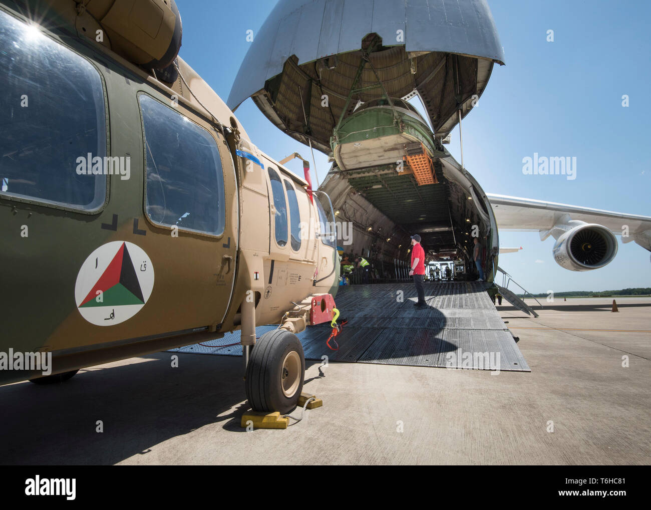 I membri del team di un Huntsville a base di industria della difesa contraente, SES-io che ristrutturato questi due UH-60 Black Hawk elicotteri per l'Afghanistan sotto un esercito degli Stati Uniti di sicurezza comando assistenza militare straniera caso vendite, preparare per caricare gli elicotteri in un Antonov un-124, all'aeroporto di Huntsville, AL, 26 aprile 2019. US Army Foto di Richard Bumgardner, USASAC affari pubblici. Foto Stock