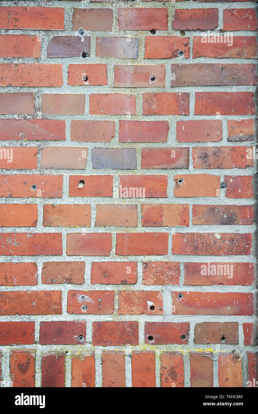 Muro di mattoni con fori Foto Stock